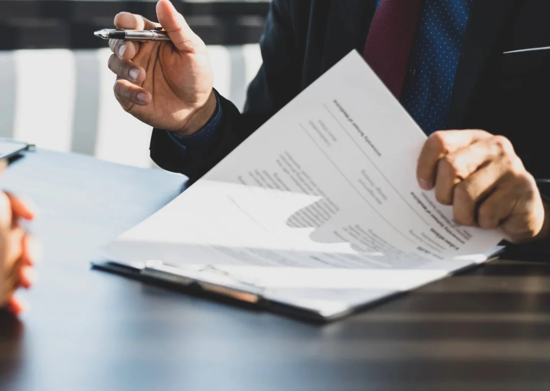 A man in a suit negotiating with a document in his hand.